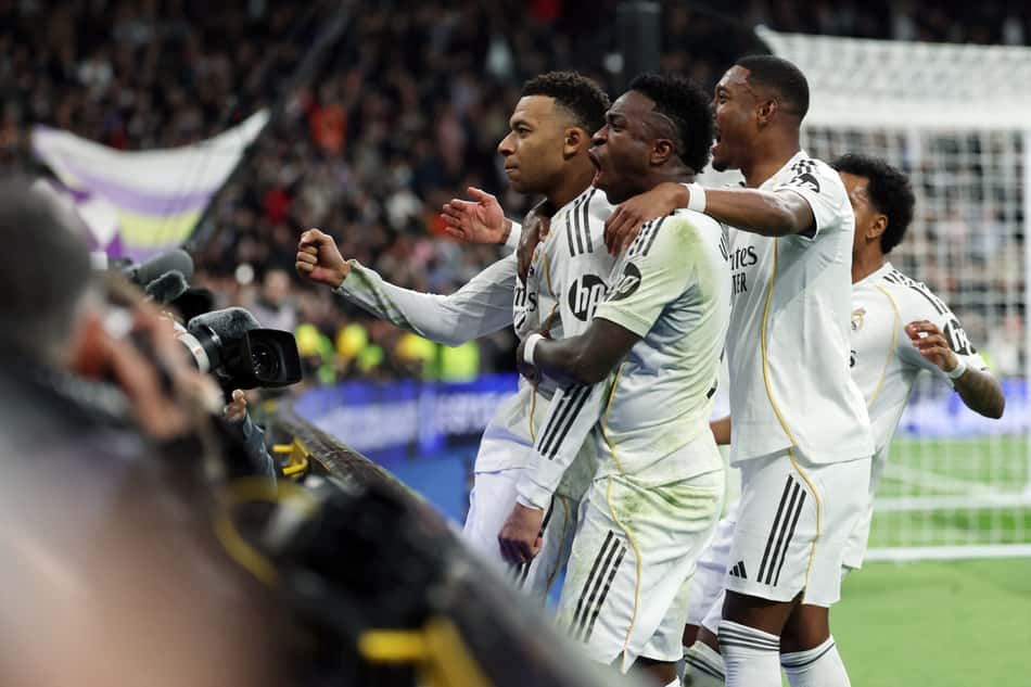 Alaba e Vini Jr comemorando o gol de Mbappé, na vitória do Real Madrid sobre o Rayo Vallecano (Foto: Thomas Coex/AFP)