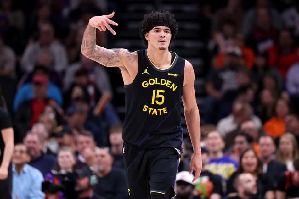 Gui Santos, com o uniforme preto do Golden State Warriors, faz um gesto de "três" com a mão para comemorar cesta em jogo da NBA