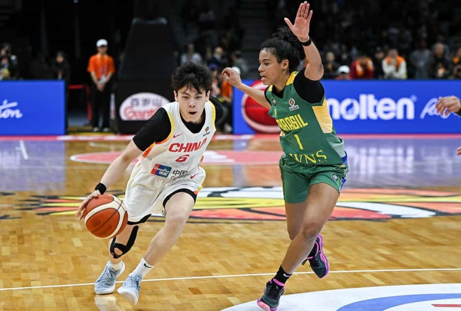 A chinesa Yang Shuyu tenta passar pela marcação da brasileira Bella Nascimento em Wuhan (Foto: CN-STR / AFP)