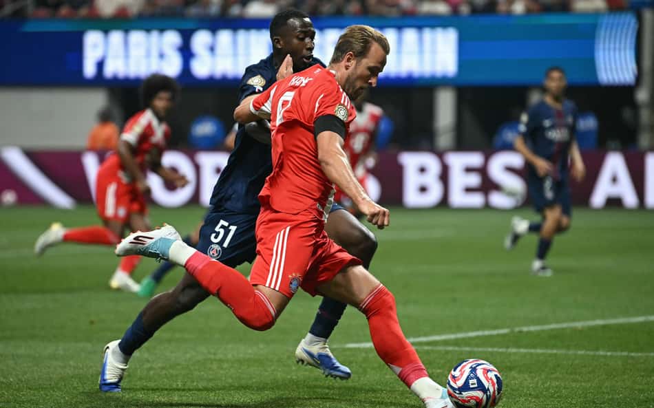 Harry Kane e Pacho disputam a bola em PSG x Bayern (Foto: Paul ELLIS / AFP)