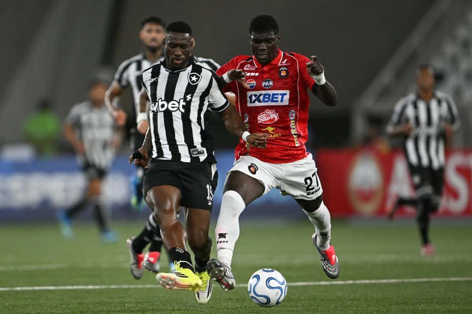 Bastos, zagueiro do Botafogo, disputa a González, do Caracas