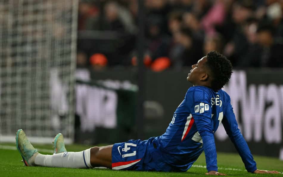 Estêvão caído no gramado após sentir lesão muscular na derrota do Chelsea para o Manchester United, na Premier League