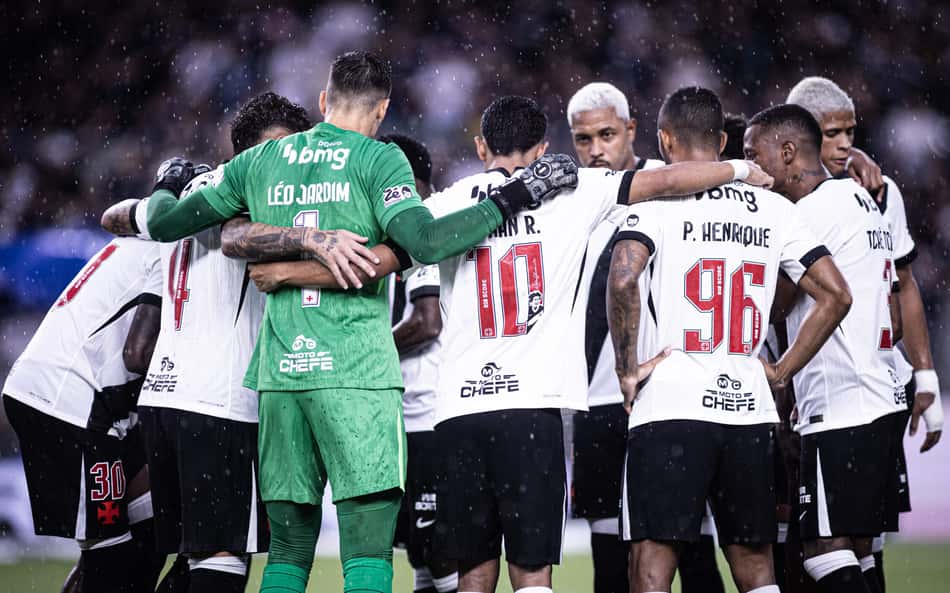 Jogadores do Vasco abraçados no gramado durante um jogo de futebol