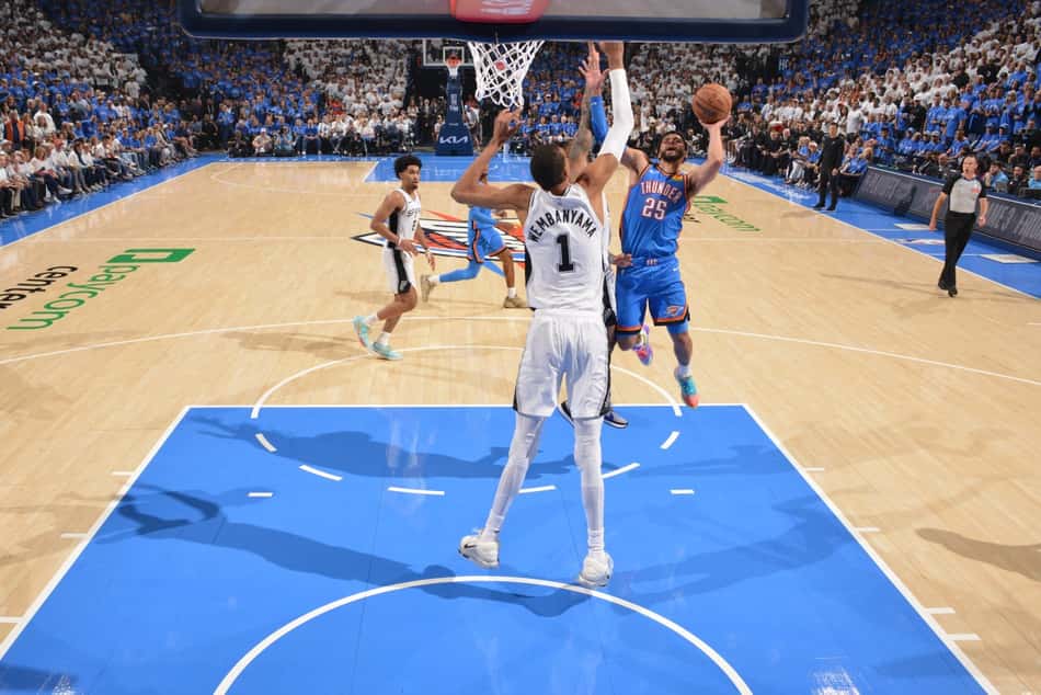 Ajay Mitchell, do Oklahoma City Thunder, recebe a marcação de Victor Wembanyama, do San Antonio Spurs (Foto: Jesse D. Garrabrant/NBAE via Getty Images/AFP)