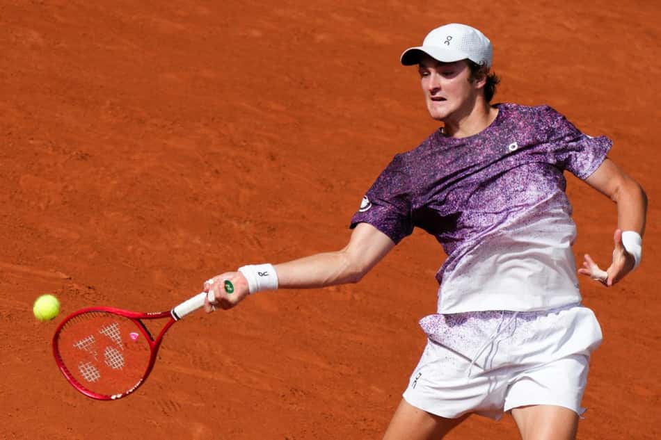 João Fonseca devolve de direita na partida contra o sérvio Novak Djokovic (Foto: Dimitar DILKOFF / AFP)