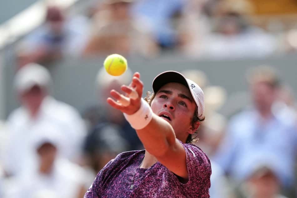 João Fonseca saca na partida contra o sérvio Novak Djokovic (Foto: Dimitar DILKOFF / AFP)