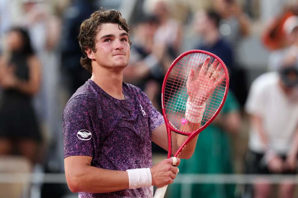 O brasileiro João Fonseca comemora após vencer o sérvio Novak Djokovic ao final da partida de simples masculina no sexto dia do torneio de tênis de Roland Garros, na quadra Philippe-Chatrier, em Paris (Foto: Dimitar Dilkoff / Afp)