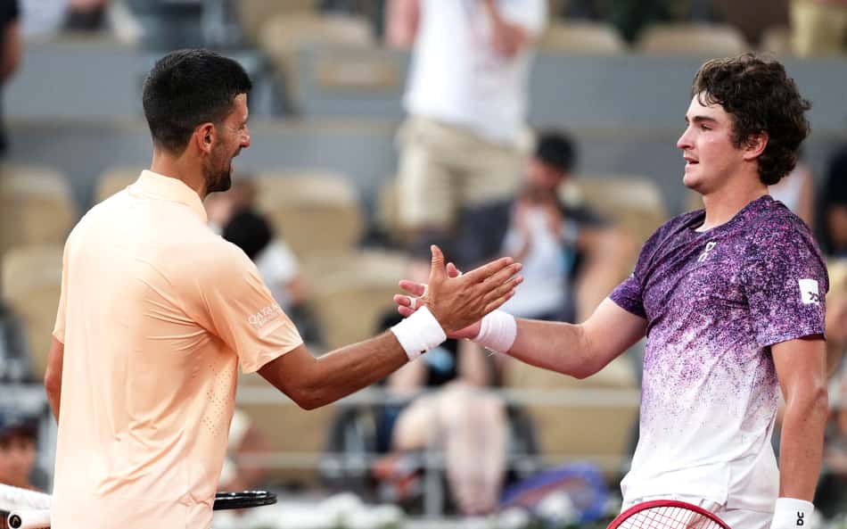 O vencedor, o brasileiro João Fonseca (à direita), cumprimenta o sérvio Novak Djokovic ao final da partida de simples masculina no sexto dia do torneio de tênis de Roland Garros, na quadra Philippe-Chatrier, em Paris (Foto: Dimitar Dilkoff / Afp)