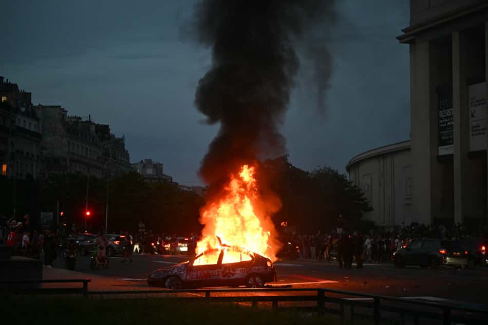 Um carro é incendiado enquanto torcedores do PSG comemoram a vitória de sua equipe na final da Champions League entre o Paris Saint-Germain (PSG) e o Arsenal FC, disputada em Budapeste, na Place du Trocadéro, em Paris (Foto: Lou Benoist / AFP)