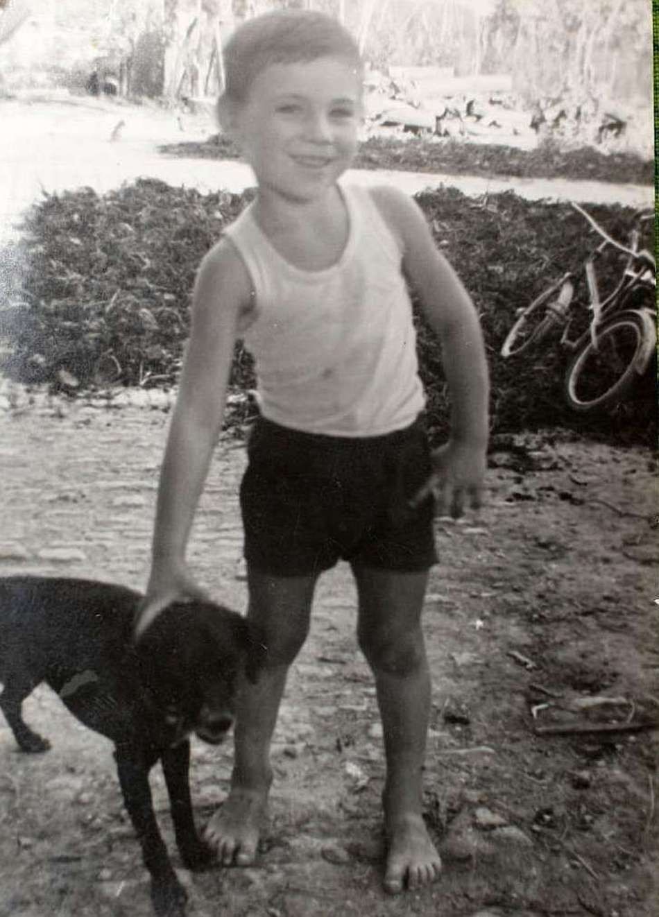 Ancelotti em foto preto e branco quando criança com um cachorro em sua cidade natal na Itália, Regiolo