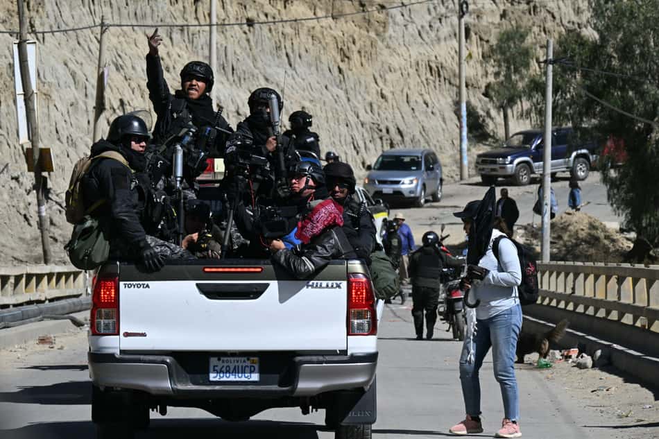 Policiais de choque viajam na traseira de uma caminhonete durante confrontos com manifestantes rurais em Lipari, no departamento de La Paz, Bolívia, em 16 de maio de 2026.  O governo da Bolívia chegou a um acordo em 15 de maio com milhares de mineiros que entraram em confronto com a polícia em um protesto que paralisou o centro de La Paz. No entanto, outros setores continuam bloqueando as vias de acesso à cidade, sede do Poder Executivo e do Congresso.
