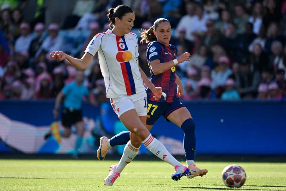 Jogadoras de Lyon e Barcelona disputam a bola no meio-campo durante jogo