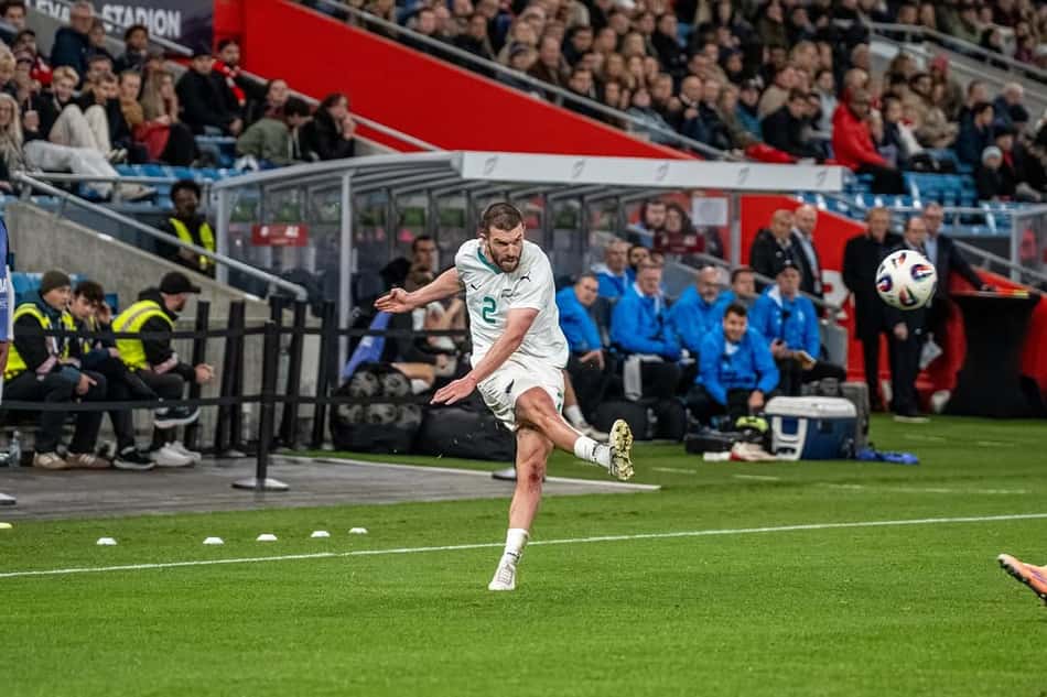 Zagueiro Tim Payne finaliza com a perna direita, que está suspensa no ar, e a bola flutua a sua frente