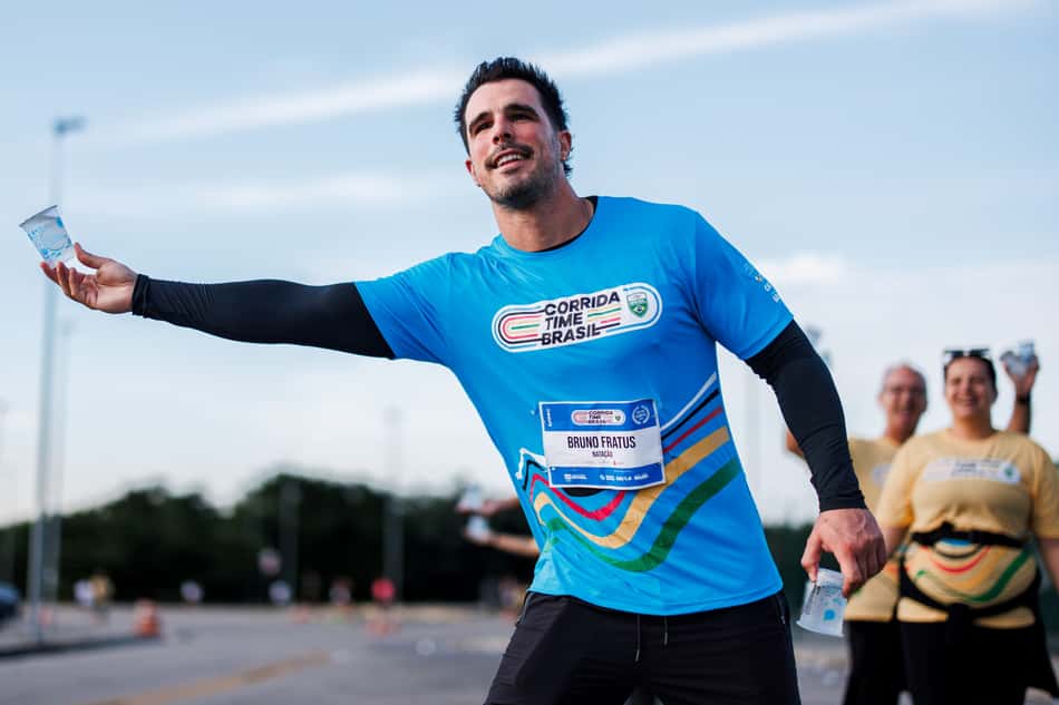 Bruno Fratus entregando água na Corrida Time Brasil 2025 (Foto: Alexandre Loureiro/COB)
