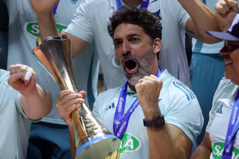 O técnico do Sada Cruzeiro, Filipe Ferraz, segura a taça da Superliga