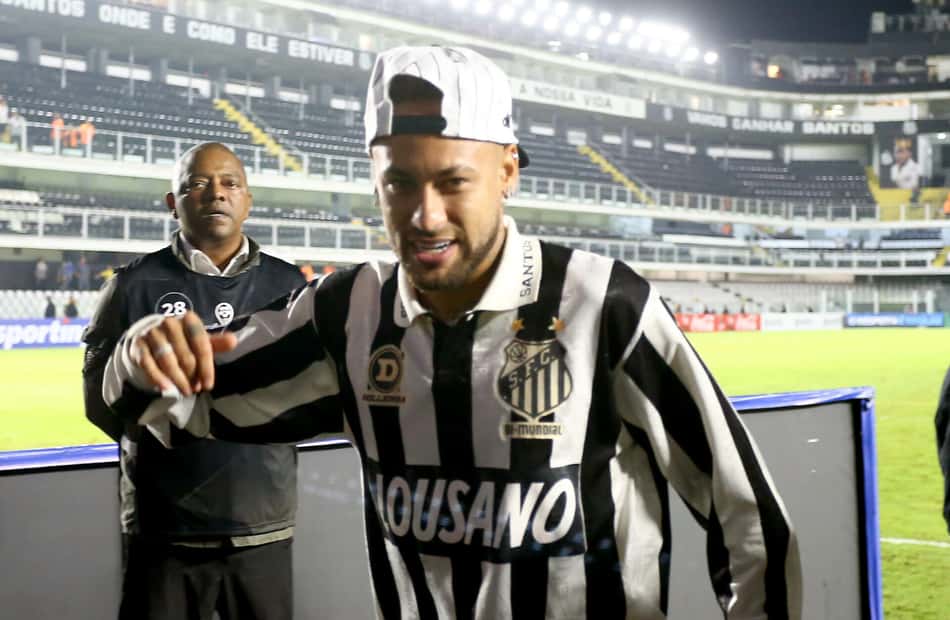 Neymar sorri de boné para trás com a camisa alvinegra de manga longa na Vila Belmiro