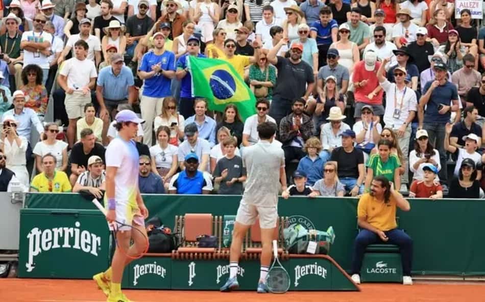 João Fonseca e o francês Pierre-Hugues Herbert em quadra pela segunda rodada da chave principal de simples em Roland-Garros, na tarde desta quinta-feira (29), em Paris. Foto: © RENE-WORMS Pierre / RFI