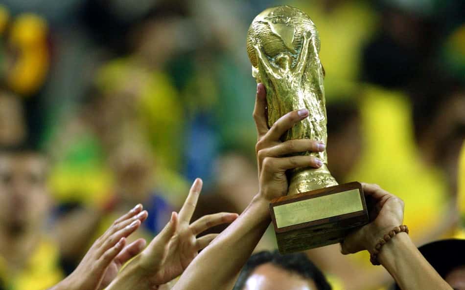 Torcedores brasileiros erguem uma réplica do troféu da Copa do Mundo para celebrar a classificação da Seleção Brasileira para a final do Mundial de 2002. (Foto: Juca Varella/Folhapress)