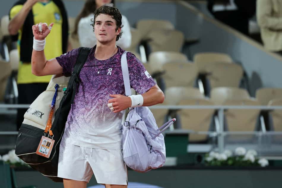 O brasileiro João Fonseca deixa a quadra após perder para o tcheco Jakub Mensik ao final da partida de quartas de final de simples masculina no décimo dia do torneio de tênis de Roland Garros, na quadra Philippe-Chatrier, em Paris (Foto: Thomas Samson / Afp)