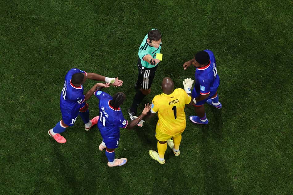 Jogadores do Haiti em volta do árbitro, reclamando pela aplicação do cartão amarelo durante a Copa do Mundo de 2026.