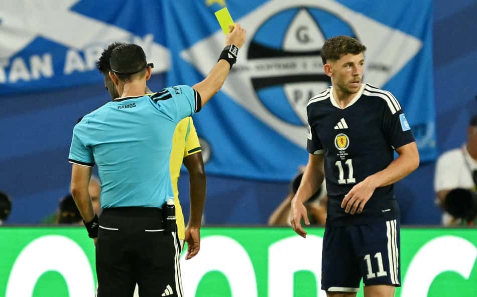 Jogador do Brasil sendo advertido com cartão amarelo durante a partida contra a Escócia na Copa do Mundo de 2026