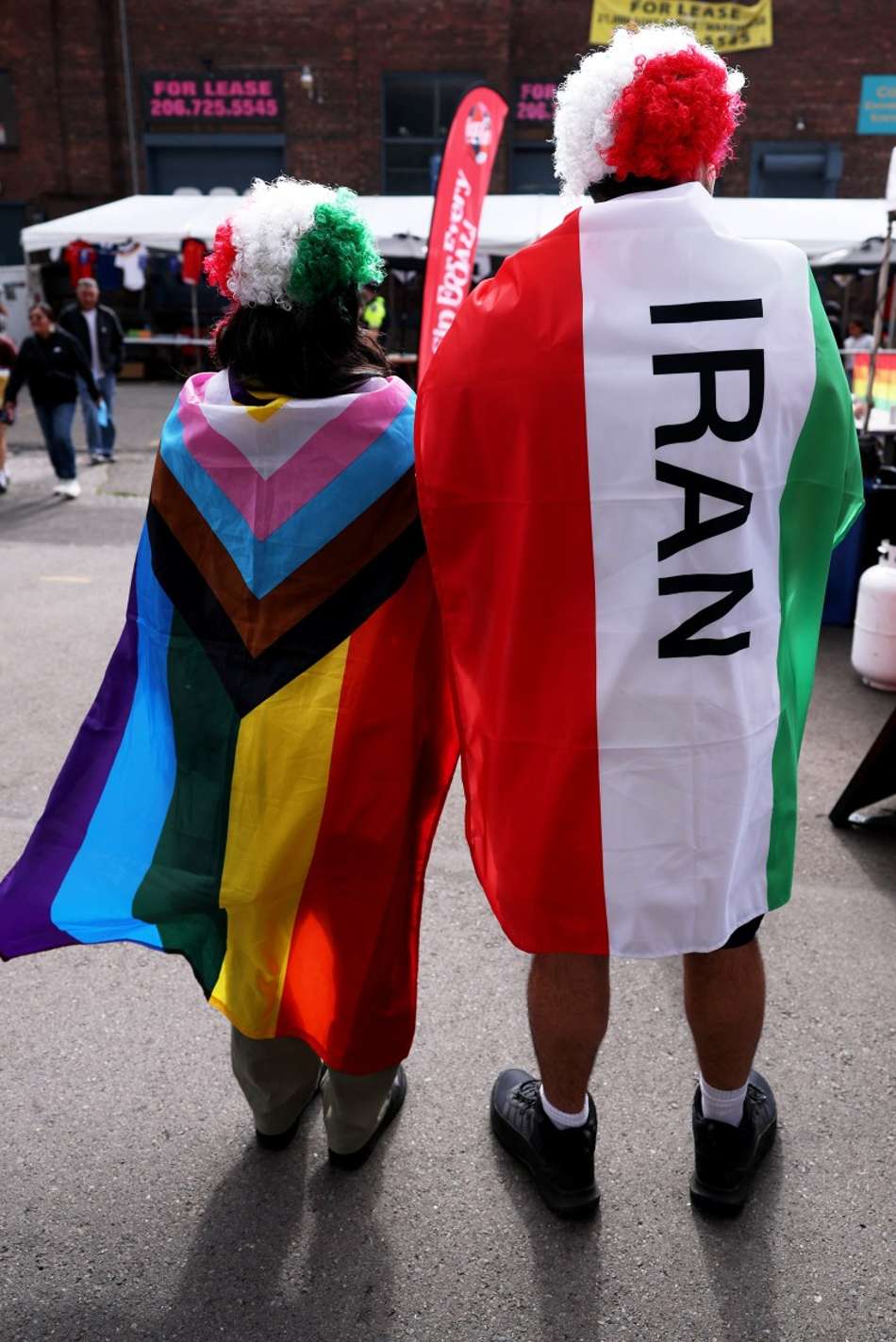 Torcedores com uma bandeira do arco-íris e a bandeira do Irã chegam antes da partida do Grupo G da Copa do Mundo da FIFA 2026 entre Egito e Irã