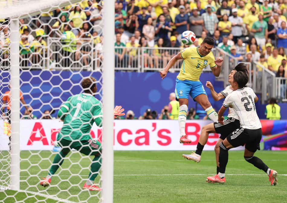 Casemiro salta e cabeceia diante do goleiro Suzuki para marcar o primeiro gol do Brasil na partida contra o Japão pela Copa do Mundo