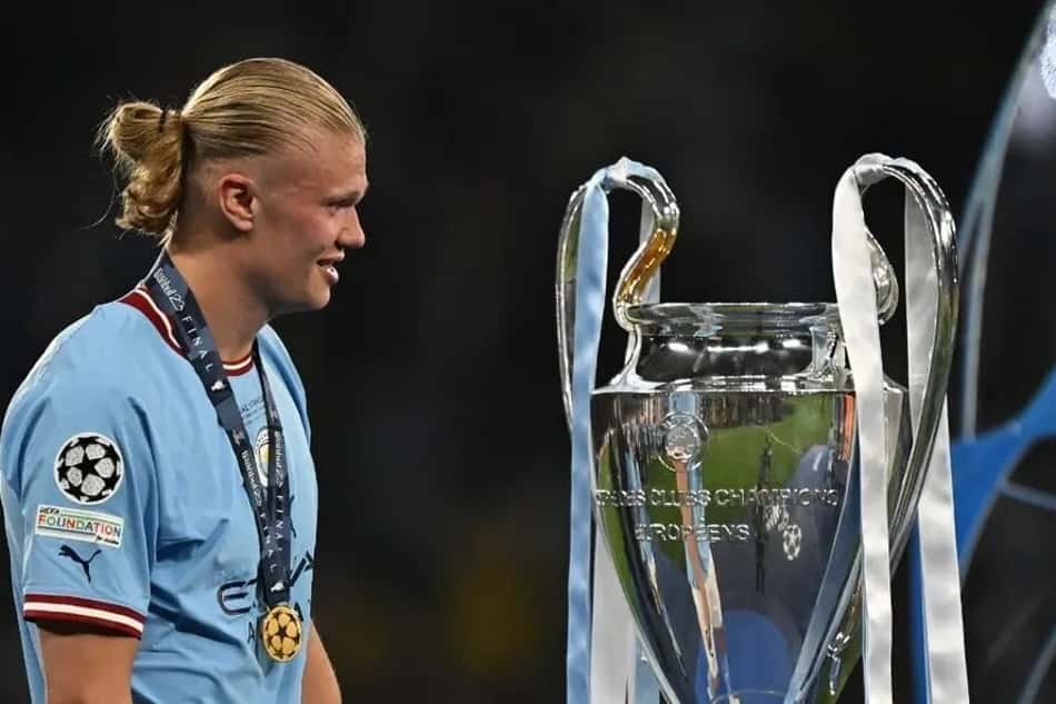 Haaland olha para o troféu da Champions Leaguea após vitória na final