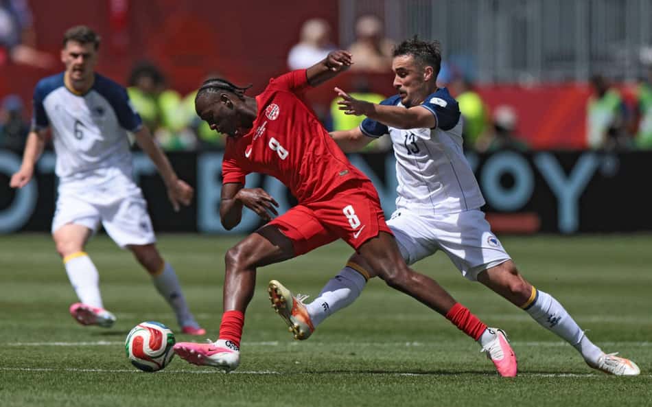 O meio-campista canadense #08 Ismael Kone (C) disputa a bola com o meio-campista da Bósnia-Herzegovina, #13 Ivan Basic, durante a partida do Grupo B da Copa do Mundo de 2026 entre Canadá e Bósnia e Herzegovina no Estádio de Toronto, em Toronto, em 12 de junho de 2026