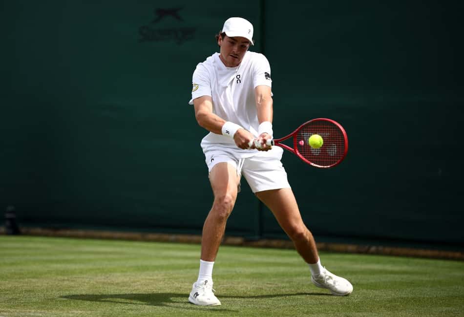 João Fonseca devolve de esquerda contra o espanhol Roberto Bautista Agut na estreia em Wimbledon