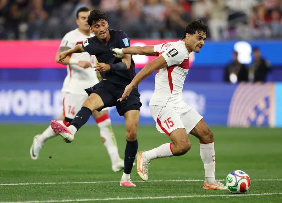 Jogador da Turquia usa os braços para se proteger de defensor americano