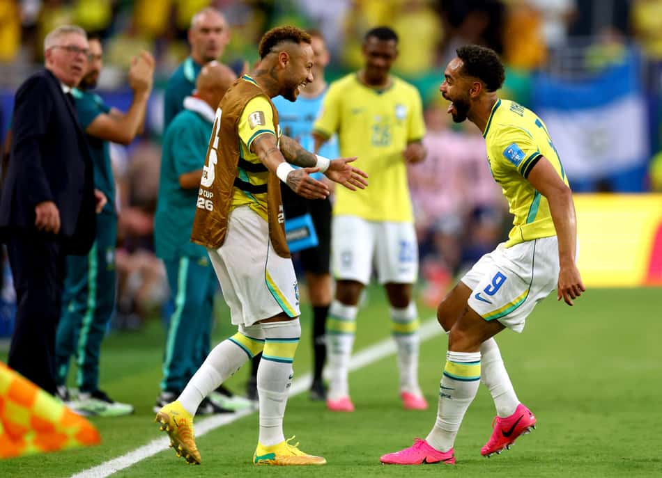Matheus Cunha corre em direção ao banco de reservas para abraçar Neymar, que usa um colete, em Brasil x Escócia