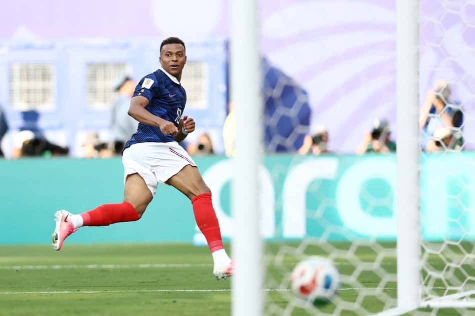 Mbappé acompanha a trajetória da bola cruzar a linha para selar o seu segundo gol da vitória da França sobre a Suécia