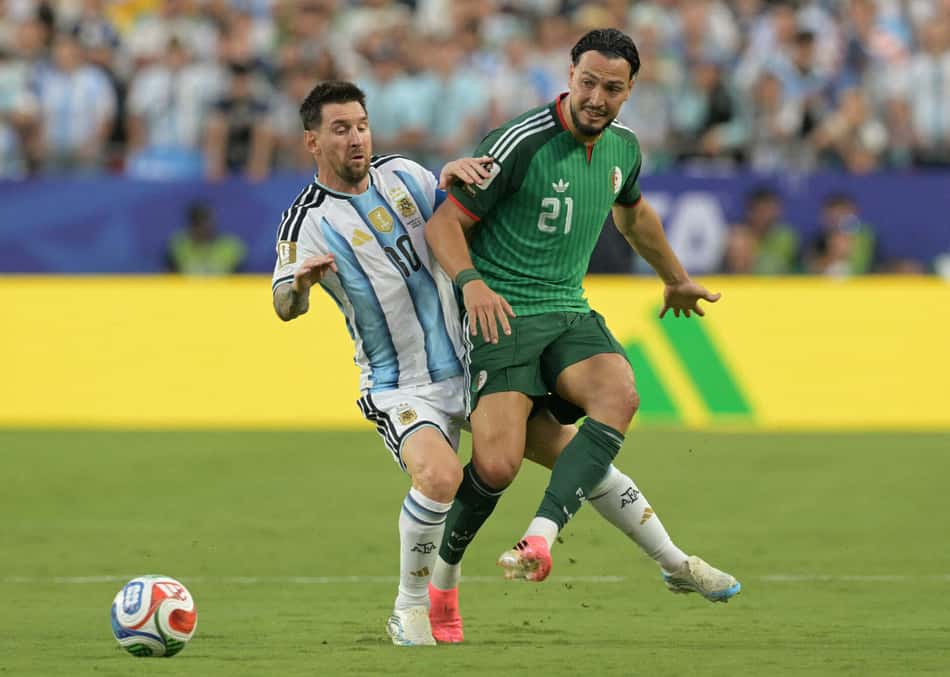Messi disputa bola com Bensebaini em Argentina x Argélia, pela Copa do Mundo