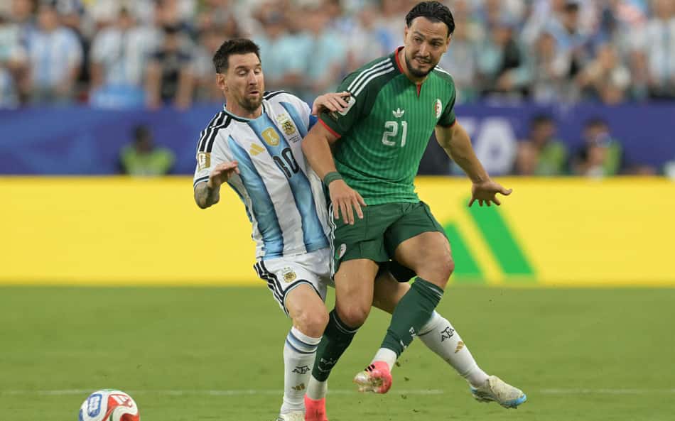 Messi disputa bola com Bensebaini em Argentina x Argélia, pela Copa do Mundo