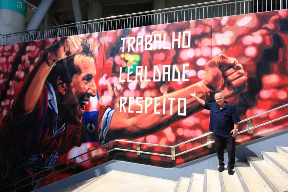 Zico em frente ao mural no estádio do Kashima, com o dizer: "Trabalho, leandro e respeito"