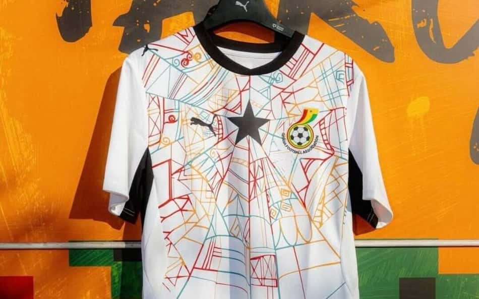 Camisa 2 da Seleção de Gana em um muro amarelo.