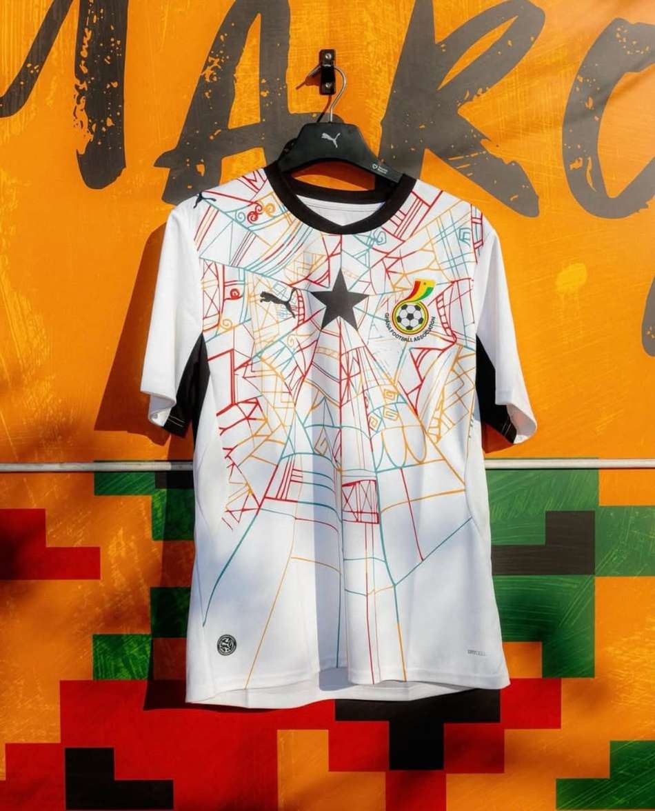Camisa 2 da Seleção de Gana em um muro amarelo.