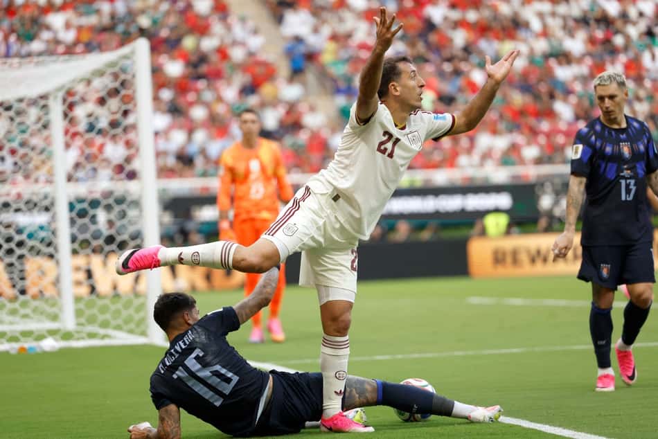 Uruguaio Mathias Olivera divide a bola com o espanhol Mikel Oyarzabal (Foto: Ulises RUIZ / AFP)
