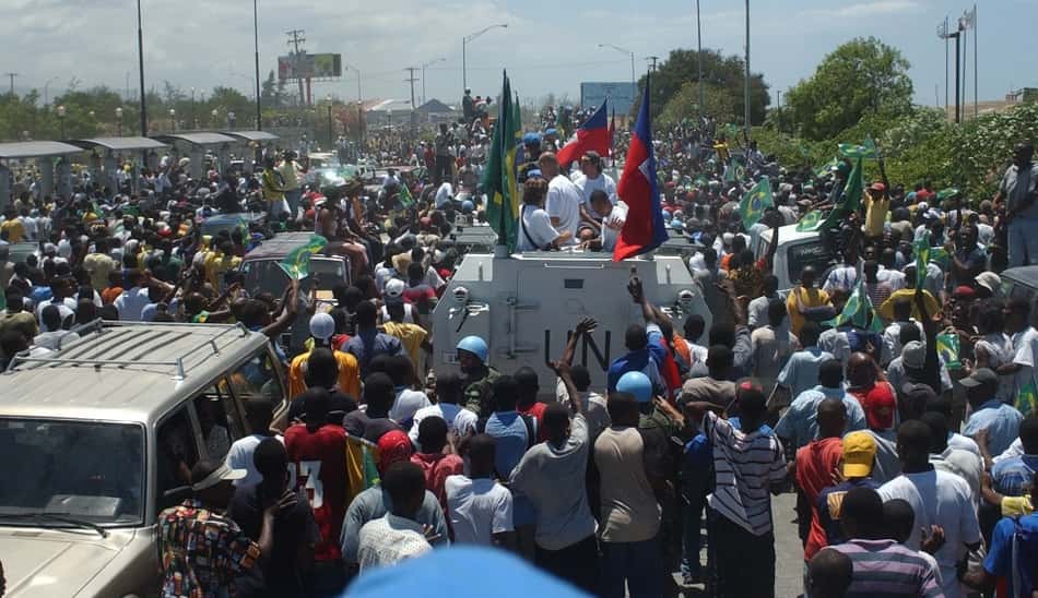 Jogadores brasileiros desfilam no meio das ruas de Porto Príncipe, no Haiti, em 2004
