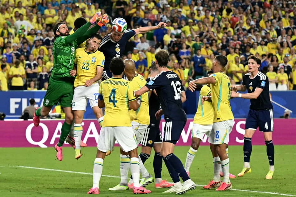 Alisson salta para afastar bola durante Brasil x Escócia
