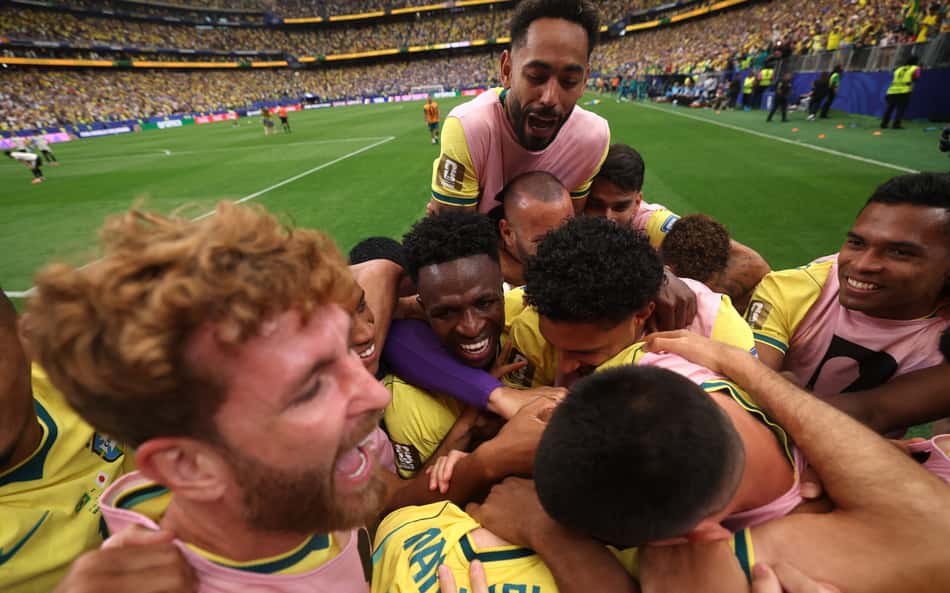 Matheus Cunha, Leo Pereira, Vini Jr, Alex Sandro e outros jogadores se abraçando após gol marcado