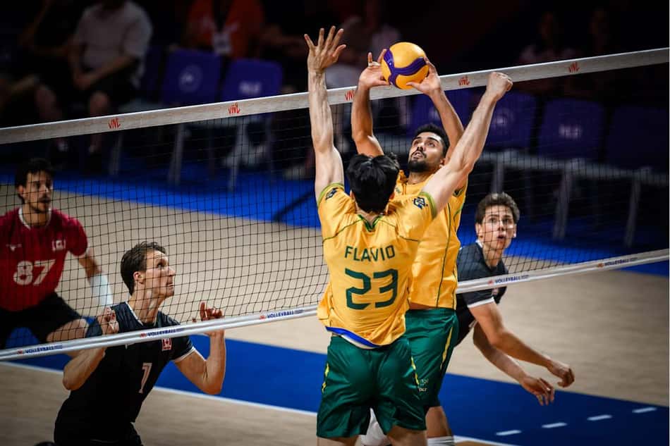 Fernando Cachopa realiza ação de levantamento e Flávio se movimenta para atacar em Brasil x Canadá pela Liga das Nações de Vôlei Masculino