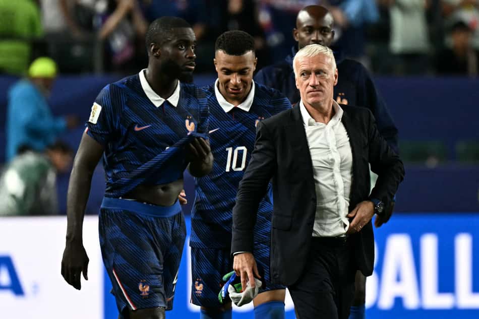 Jogadores da França com o técnico Didier Deschamps caminhando em campo