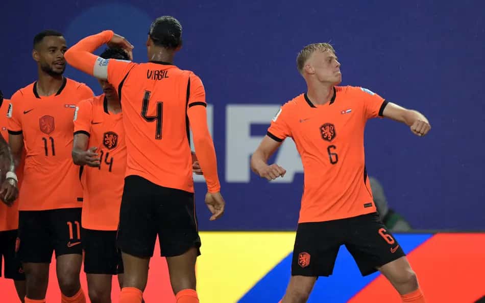 Van Hecke, zagueiro da Holanda, comemora com os demais companheiros o gol marcado na vitória sobre a Tunísia