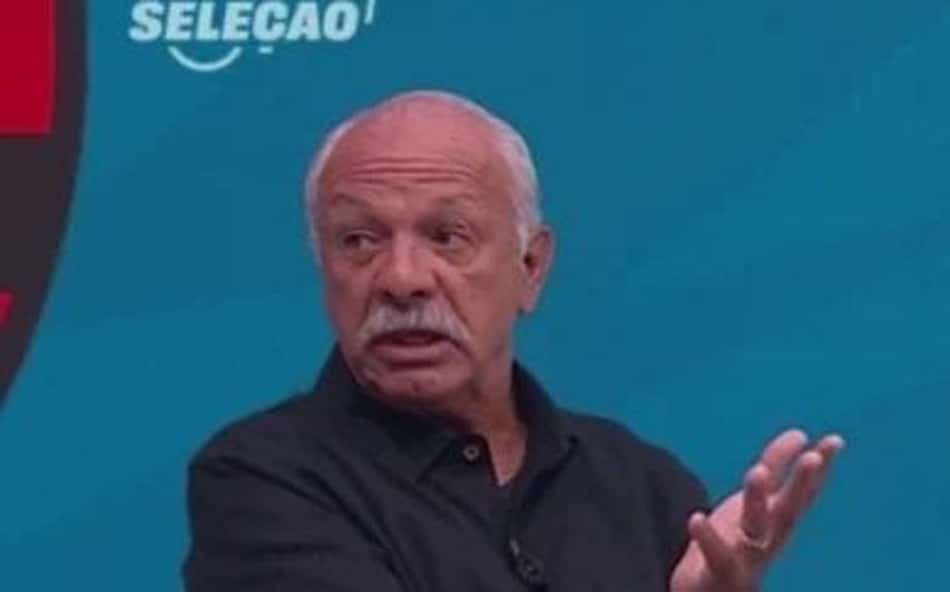 Mastro Junior com a mão levantada de camisa de botão preta