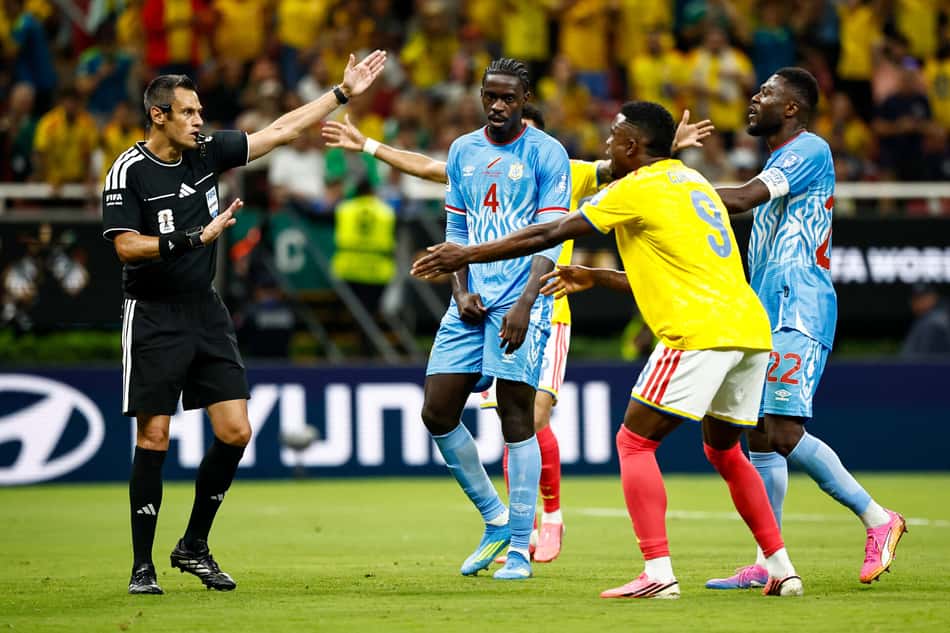 Maurizio Mariani, de camisa preta e com o emblema da Fifa, apita falta e é alvo de reclamação de Jhon Cordoba em Colômbia x RD Congo