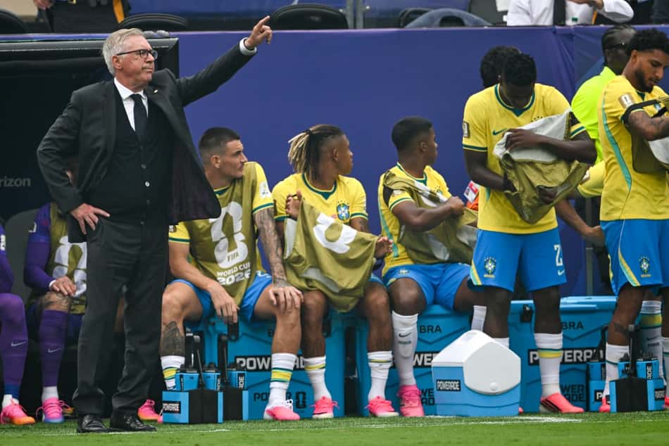 Carlo Ancelotti orienta a Seleção Brasileia à beira do gramado sob os olhares dos jogadores erservas