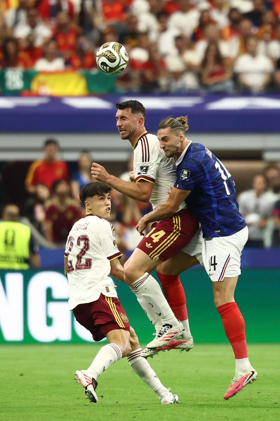 Pau Cubarsí e Aymeric Laporte, da Espanha, disputam a bola com o meio-campista francês Adrien Rabiot durante a semifinal entre França e Espanha.