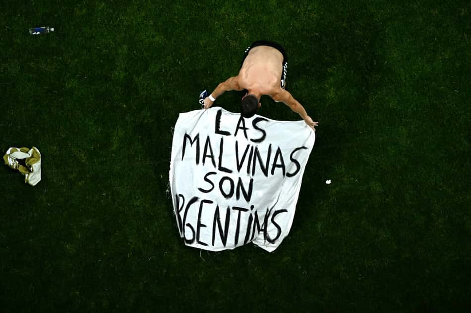 Giovani Lo Celso ajustando a bandeira com os dizeres: "As Malvinas são Argentinas".